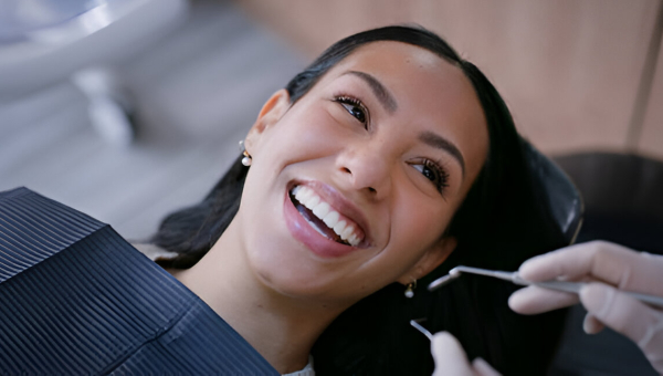 a woman happy with her dental cleanings at Gulfton Smiles in Houston